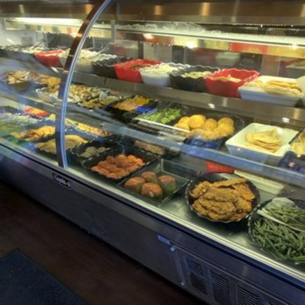 A deli case at Cogman's Creek butcher shop filled with various prepared foods and sides.